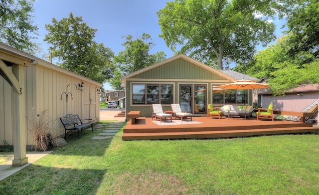 rear view of property with an outdoor hangout area, a lawn, and a deck