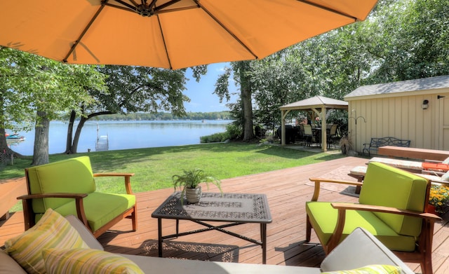 wooden deck featuring a gazebo, a lawn, and a water view