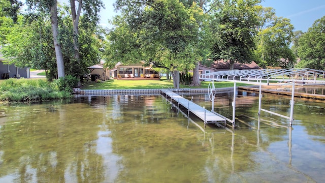 dock area with a gazebo, a lawn, and a water view