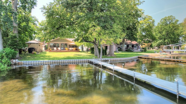 view of dock with a yard and a water view