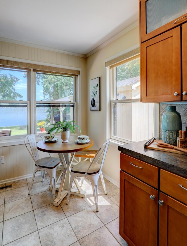 dining area featuring crown molding, plenty of natural light, and light tile patterned flooring