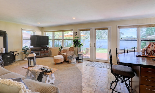 living room with recessed lighting, crown molding, light tile patterned floors, baseboards, and a wood stove