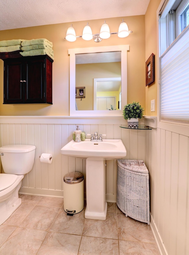 bathroom featuring a wainscoted wall and toilet