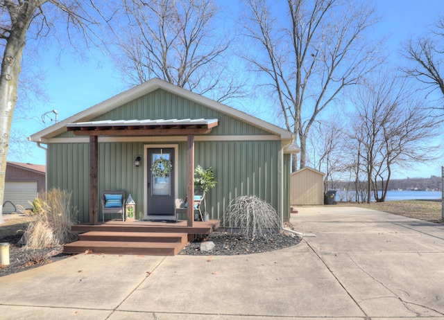 view of front of home with an outdoor structure, covered porch, and a water view