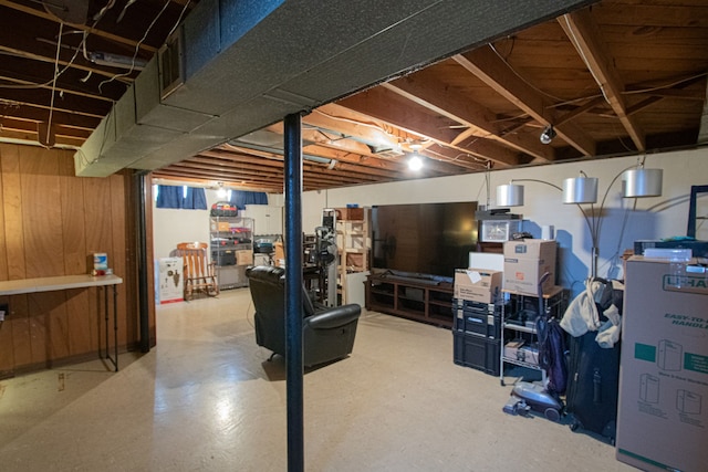 unfinished basement featuring wood walls