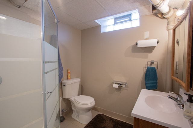 full bath featuring vanity, a stall shower, a drop ceiling, tile patterned flooring, and toilet