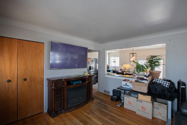 living room featuring visible vents, wood finished floors, and a fireplace