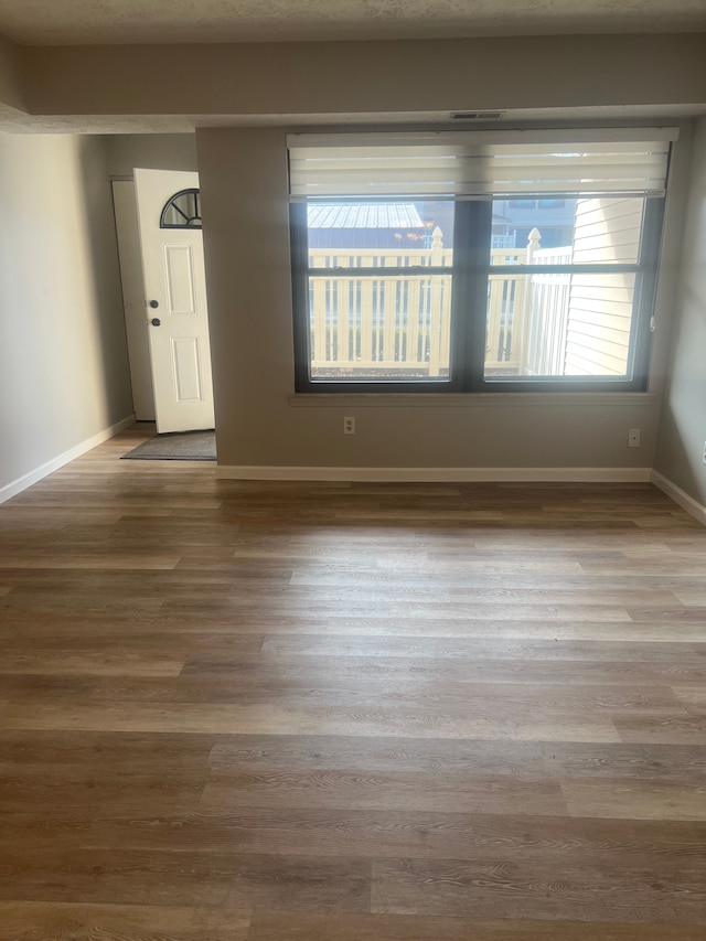 spare room featuring wood finished floors and baseboards