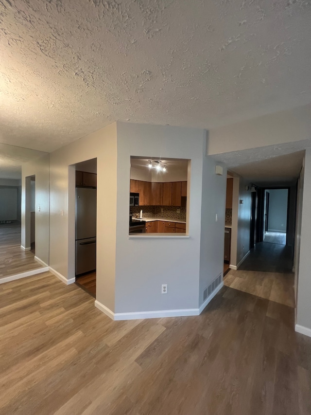 interior space with visible vents, baseboards, and wood finished floors