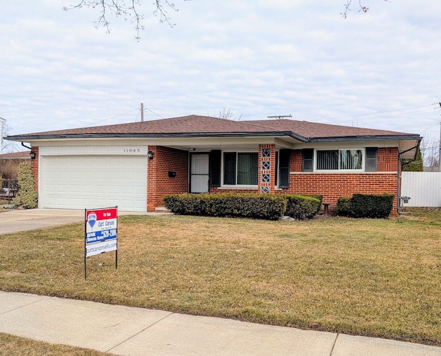 ranch-style home featuring brick siding, a front lawn, fence, concrete driveway, and an attached garage