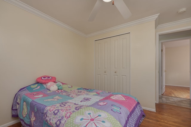 bedroom featuring ceiling fan, baseboards, ornamental molding, wood finished floors, and a closet