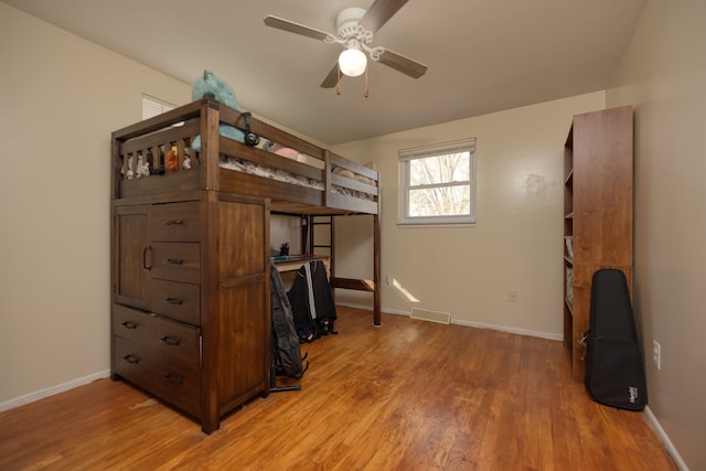 bedroom with light wood-style floors, visible vents, and baseboards