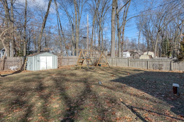 view of yard with an outbuilding, a fenced backyard, and a shed