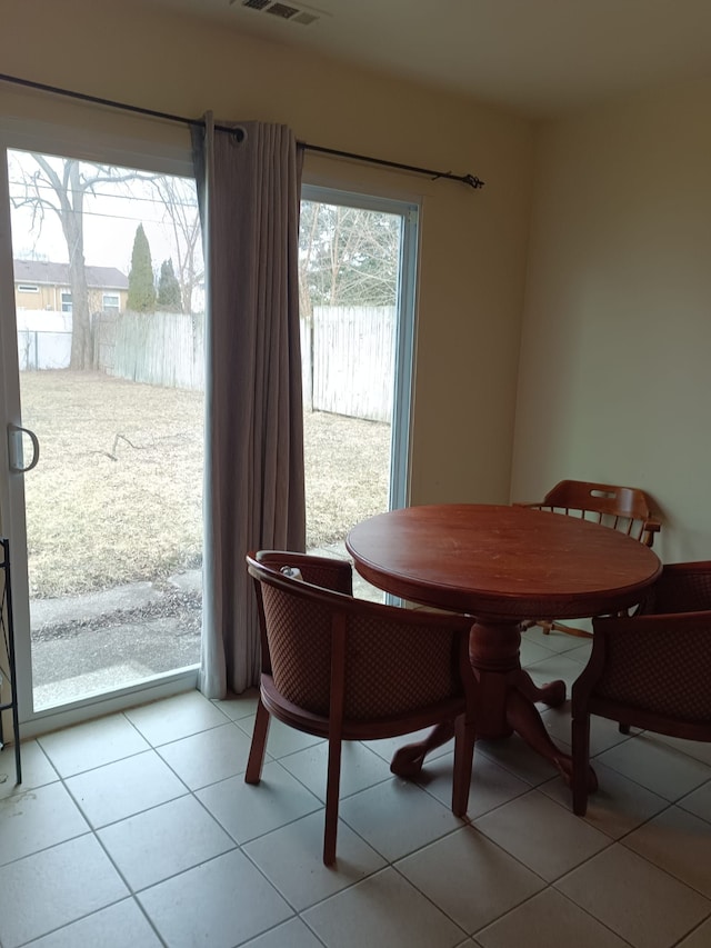 dining area with light tile patterned floors and visible vents