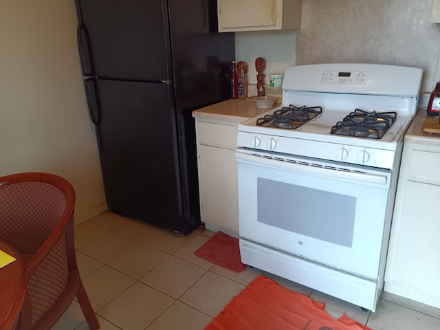 kitchen with white cabinetry, light countertops, white gas range, and freestanding refrigerator