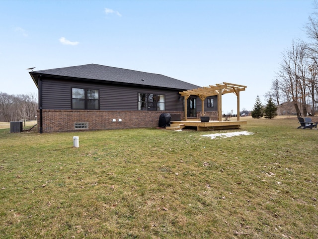 rear view of property featuring a yard, brick siding, a deck, and a pergola