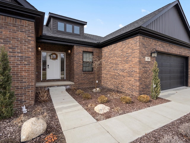 entrance to property featuring brick siding, an attached garage, and board and batten siding