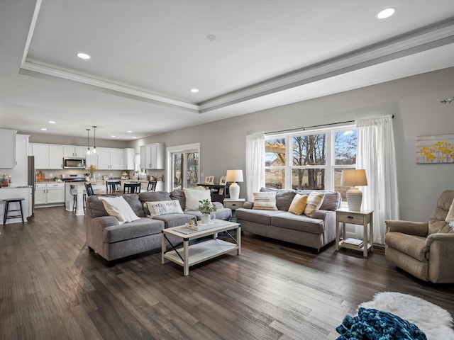 living room with recessed lighting, a raised ceiling, and dark wood-style flooring