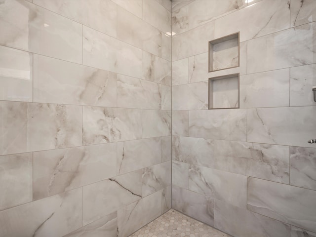 interior details featuring tiled shower