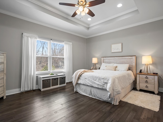 bedroom with visible vents, baseboards, a tray ceiling, and dark wood-style flooring