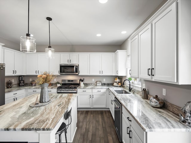 kitchen featuring dark wood finished floors, white cabinets, appliances with stainless steel finishes, and a sink