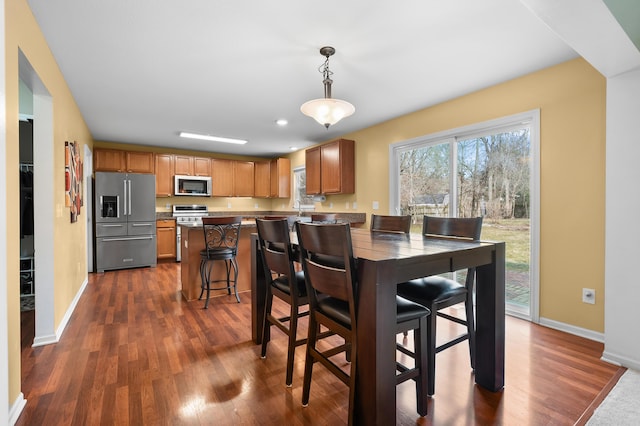 dining space featuring dark wood finished floors, recessed lighting, and baseboards