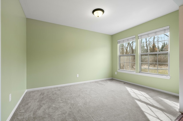 empty room featuring carpet flooring and baseboards