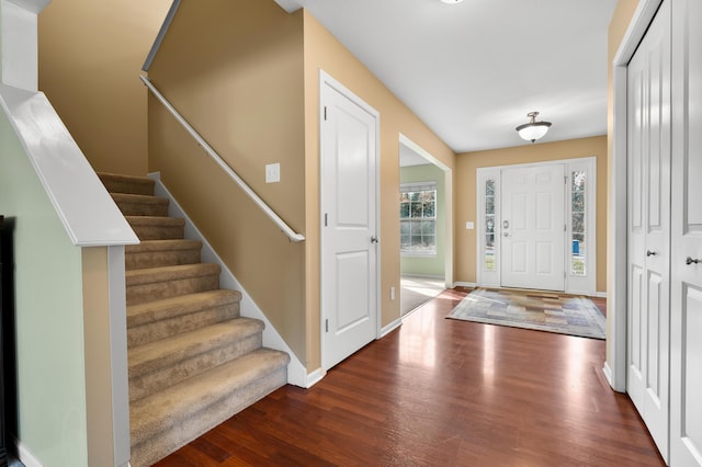 foyer entrance featuring stairway, baseboards, and wood finished floors