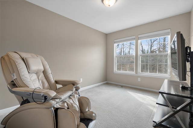 living area featuring visible vents, light colored carpet, and baseboards