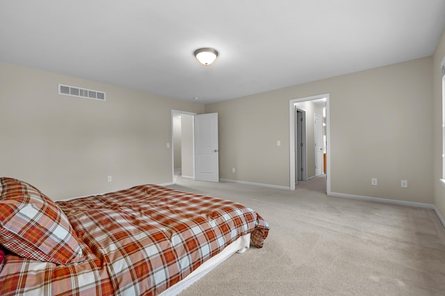 bedroom with visible vents, light colored carpet, and baseboards