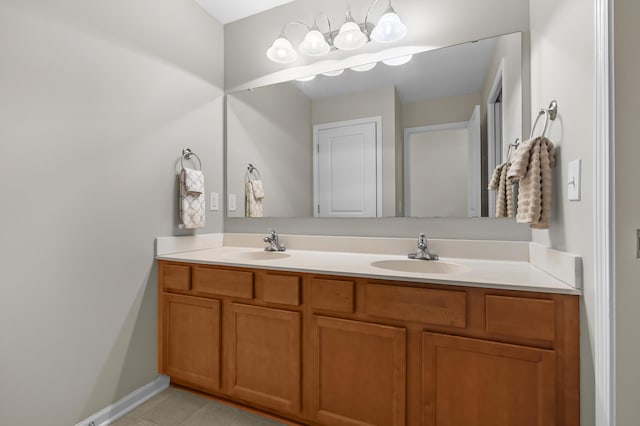 bathroom with double vanity, tile patterned floors, baseboards, and a sink