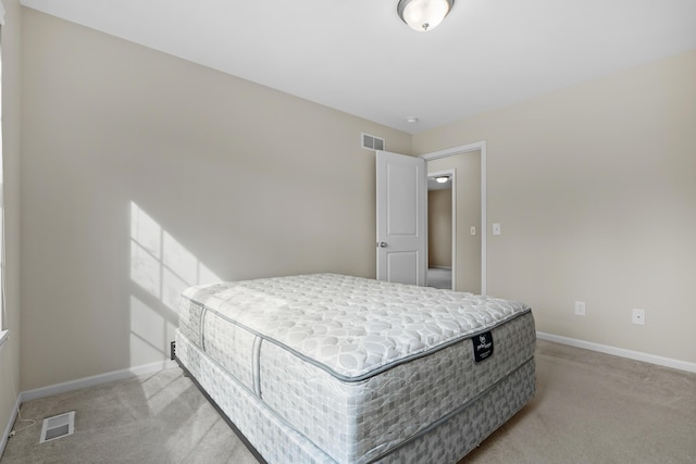 bedroom featuring visible vents, light carpet, and baseboards