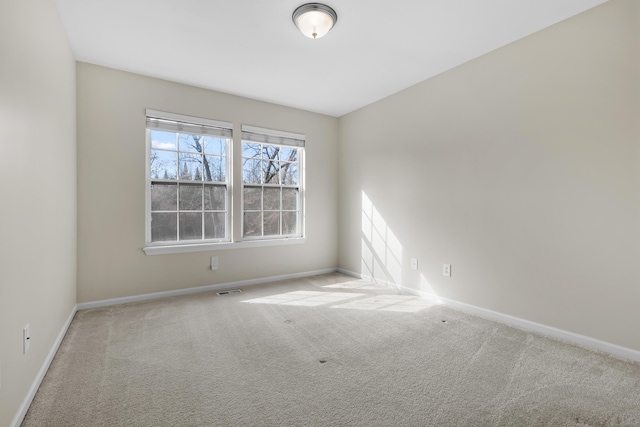 carpeted empty room featuring visible vents and baseboards