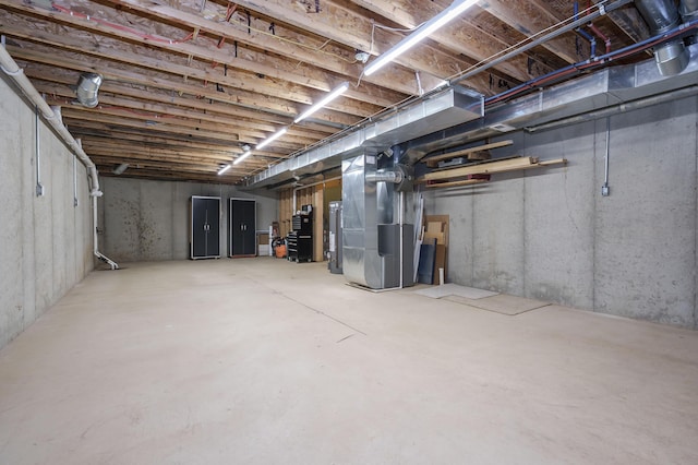 unfinished basement with water heater and heating unit