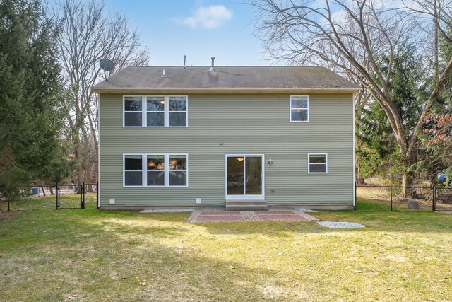 rear view of property with a gate, a patio, a lawn, and fence