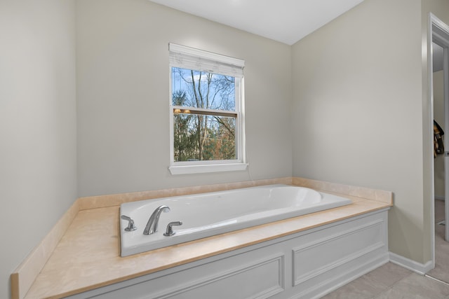 bathroom featuring baseboards and a bath