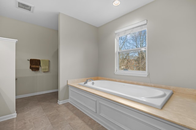 full bathroom with a garden tub, baseboards, and visible vents