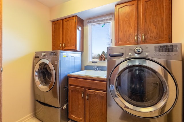 washroom with washing machine and clothes dryer, cabinet space, baseboards, and a sink