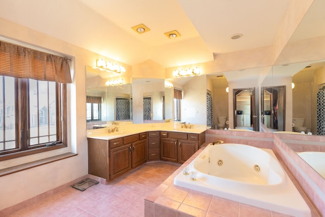 full bath featuring double vanity, a sink, toilet, and a whirlpool tub