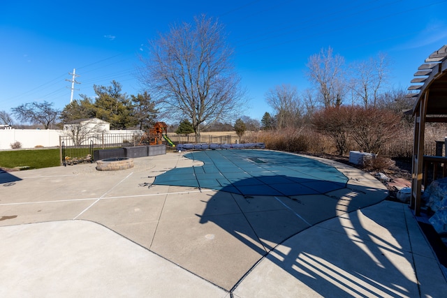 view of swimming pool with a fenced in pool, a fire pit, a fenced backyard, and a patio area