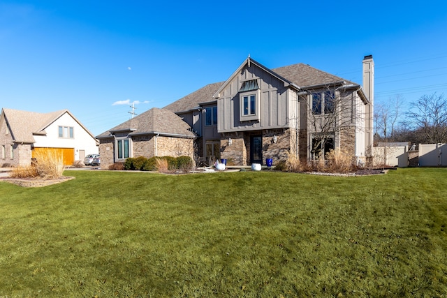 view of front of house featuring roof with shingles, board and batten siding, a front yard, and fence