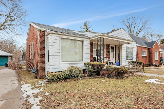 bungalow featuring a porch, brick siding, and a front lawn