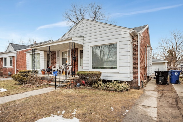 bungalow-style home with brick siding and covered porch