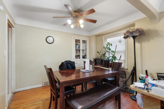 dining room with baseboards, ceiling fan, and light wood finished floors