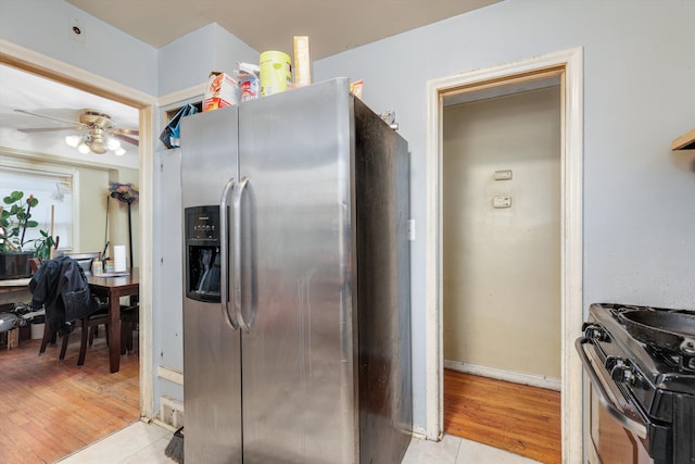 kitchen with stainless steel fridge, a ceiling fan, range with gas cooktop, and light wood-style floors