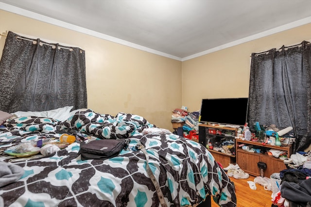 bedroom featuring crown molding and wood finished floors