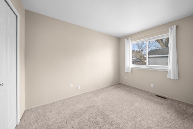 unfurnished bedroom featuring a closet, visible vents, baseboards, and carpet