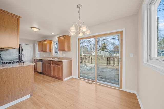 kitchen with a sink, light wood-type flooring, dishwasher, and light countertops