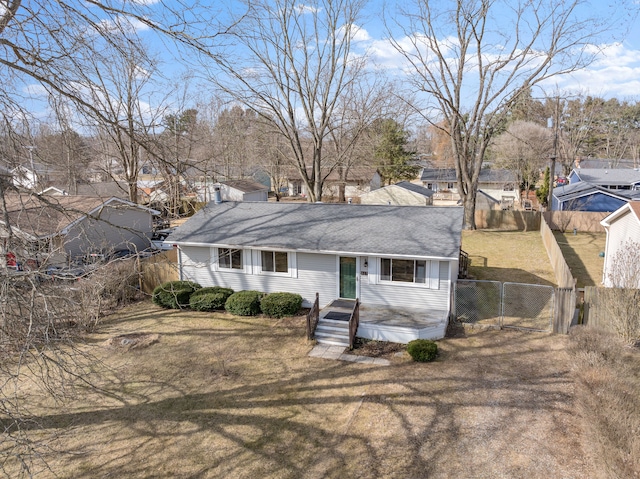 back of house featuring a lawn, fence, and a gate