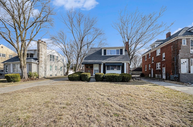 view of front of house featuring a front lawn, brick siding, and a residential view